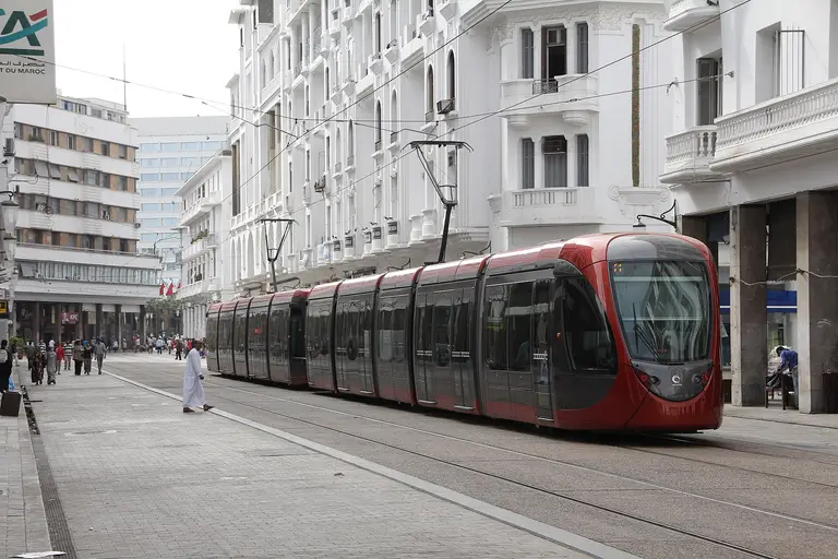 Un tramway rouge et gris sur un boulevard bordé d’immeubles Art déco blancs, à Casablanca