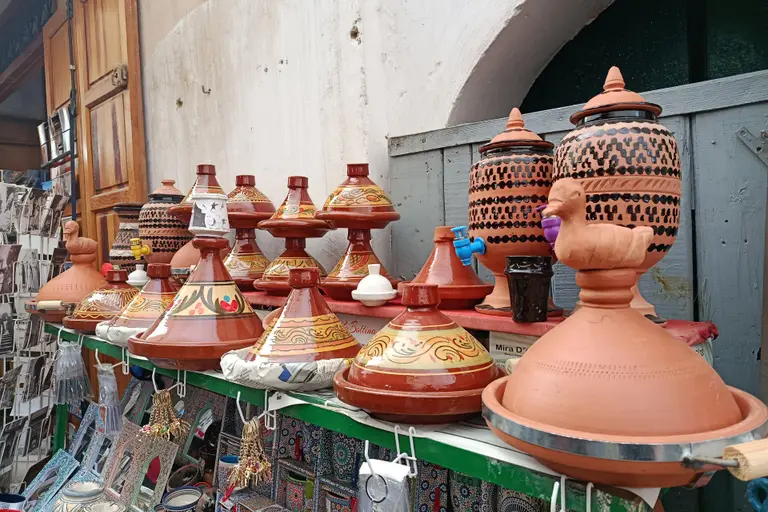 طواجن مزخرفة وفخار على رف متجر في المدينة العتيقة بفاس